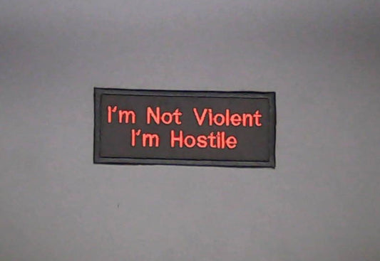 A rectangular Sew-on Patch with red  text reading 'I'm Not Violent I'm Hostile' on black background.